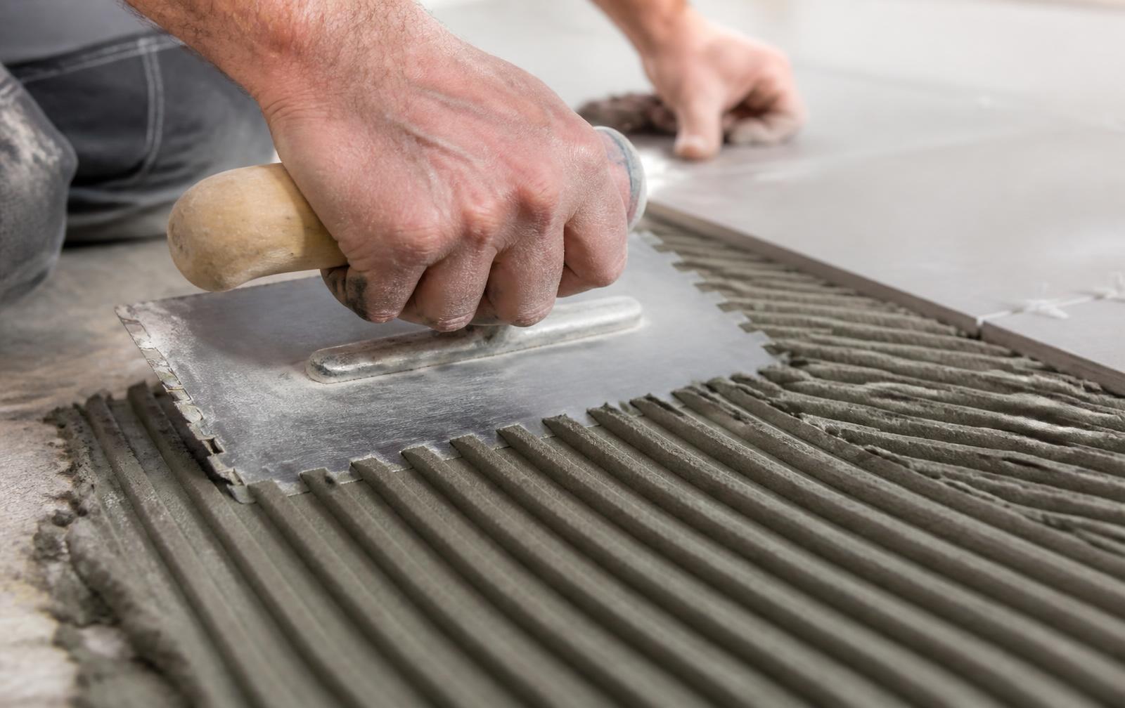 Applicator combing tile adhesive with a notched trowel